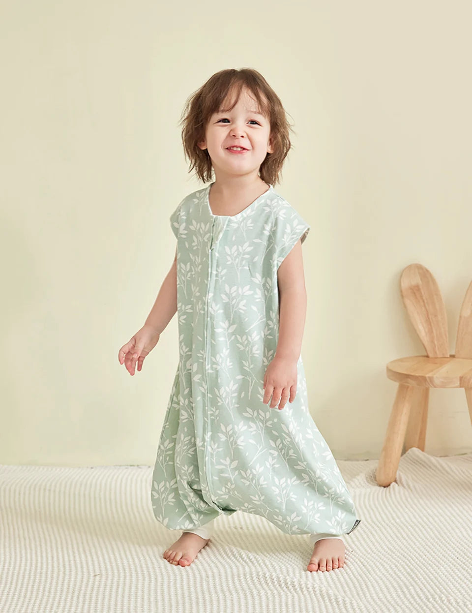Enfant marchant, deuxième vue, portant la gigoteuse à pied vert sauge
