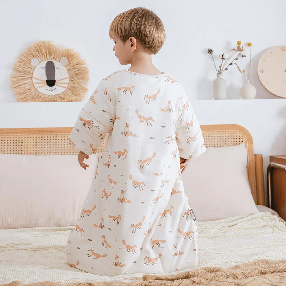 Enfant debout de dos portant la gigoteuse à motif renards